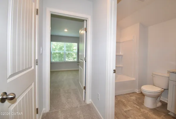 a bathroom with a granite countertop toilet a sink and a mirror