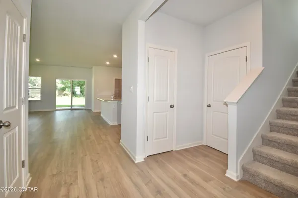 a view of a hallway with wooden floor and entryway