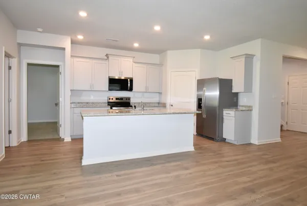 a kitchen with stainless steel appliances granite countertop a refrigerator and a stove top oven