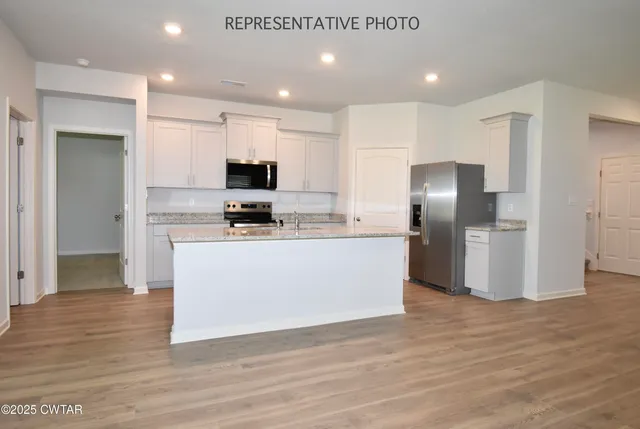 a kitchen with stainless steel appliances granite countertop a refrigerator and a stove top oven