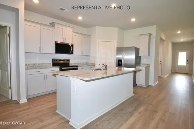 a kitchen with a sink a microwave a refrigerator and cabinets