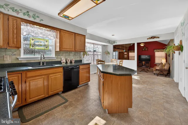 a large kitchen with stainless steel appliances granite countertop a sink counter space cabinets and a large window