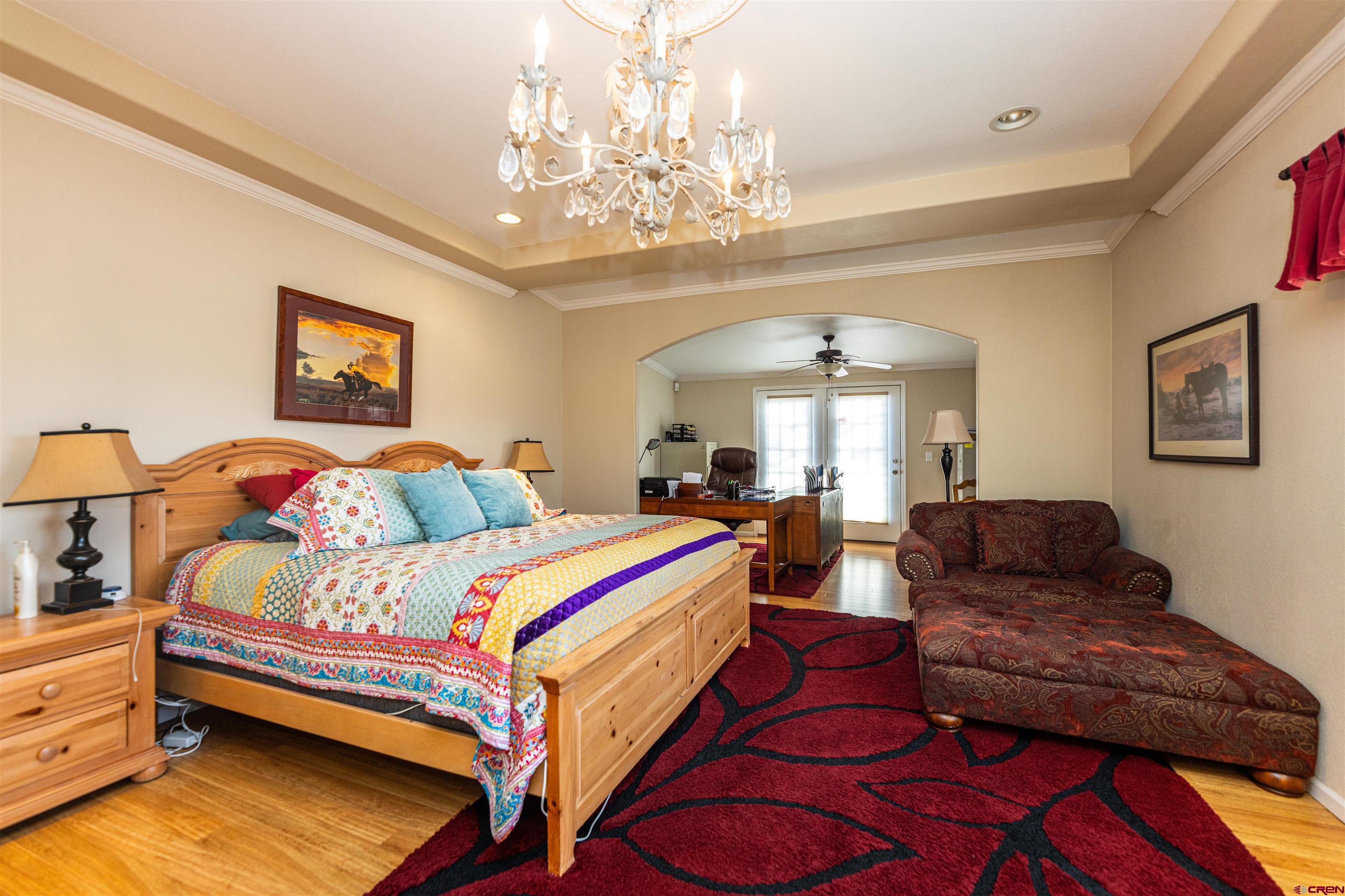 2716 Threemile Road Alamosa, CO 81101 - Photo 14 of 45 a bedroom with bed and a chandelier