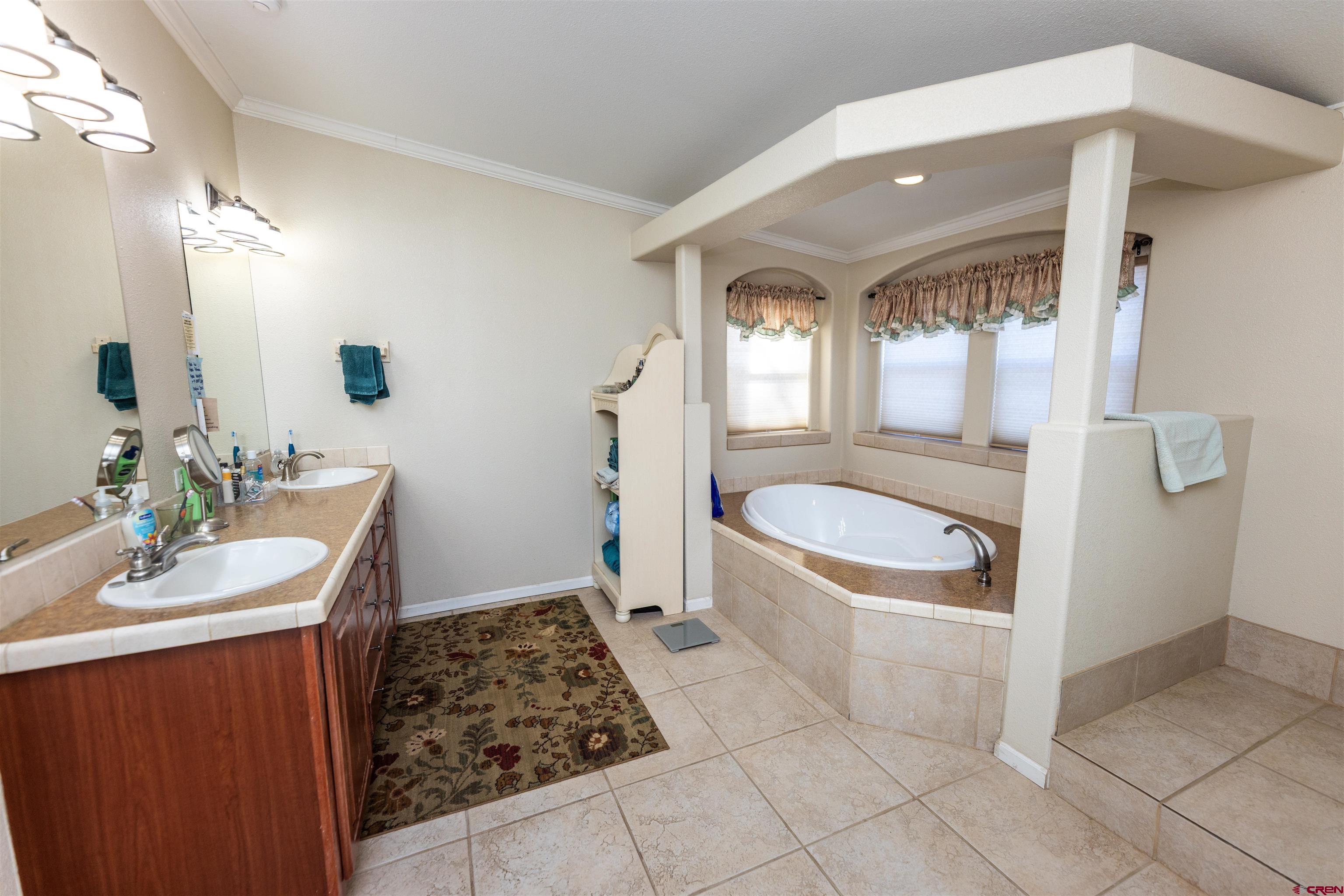2716 Threemile Road Alamosa, CO 81101 - Photo 16 of 45 a bathroom with a sink a toilet and a mirror