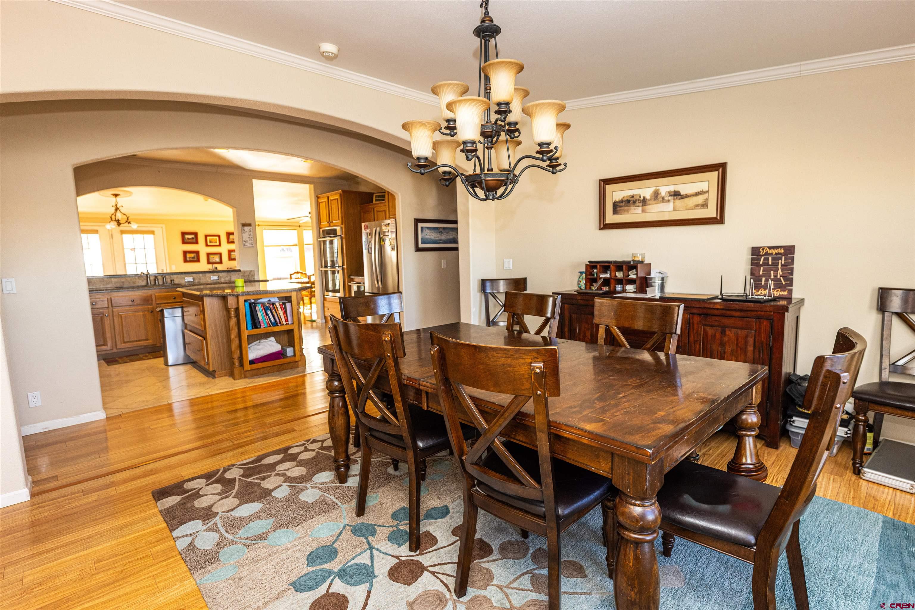 2716 Threemile Road Alamosa, CO 81101 - Photo 5 of 45 a view of a dining room with furniture a chandelier and wooden floor