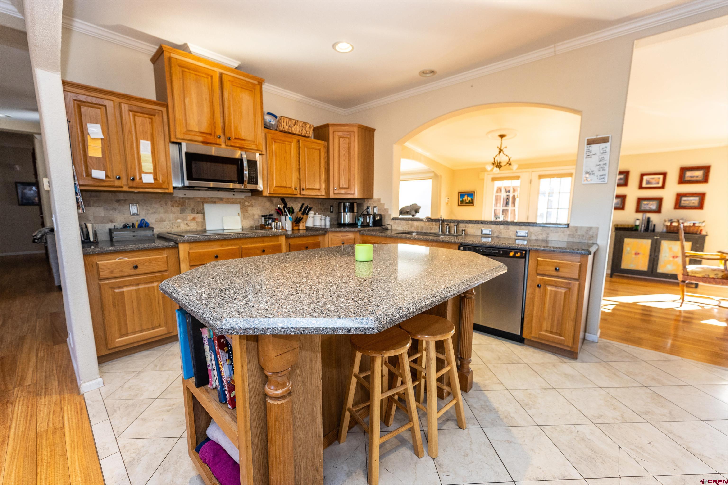 2716 Threemile Road Alamosa, CO 81101 - Photo 6 of 45 a kitchen with stainless steel appliances granite countertop a stove top oven a sink a dining table and chairs