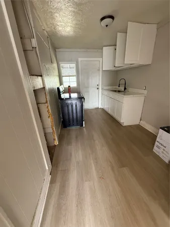 a view of kitchen with sink microwave refrigerator and cabinets