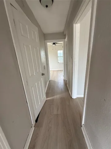 a view of a hallway with wooden floor and entryway