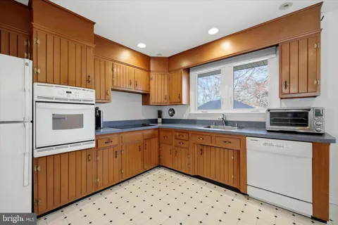 a kitchen with granite countertop cabinets stainless steel appliances a sink and a window