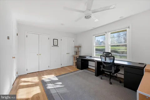 a view of a workspace with furniture and a window