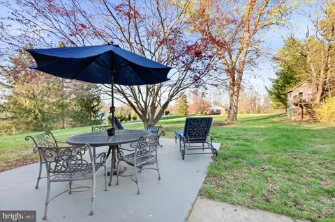 a view of patio with chairs and table under an umbrella