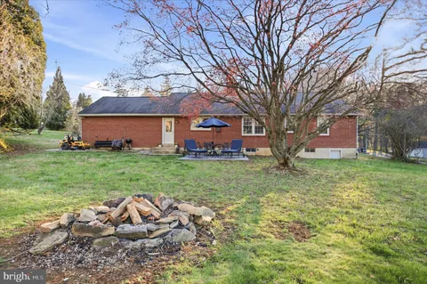 a view of a house with backyard and sitting area