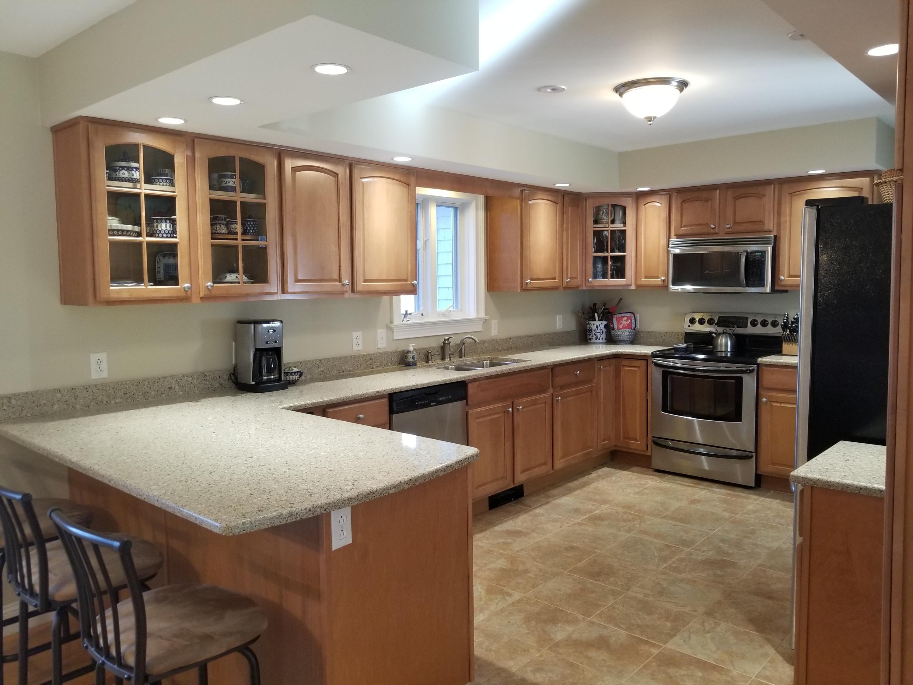 2 Easting Road Bourne, MA 02532 - Photo 2 of 34 a kitchen with stainless steel appliances granite countertop a stove top oven a sink dishwasher a dining table and chairs