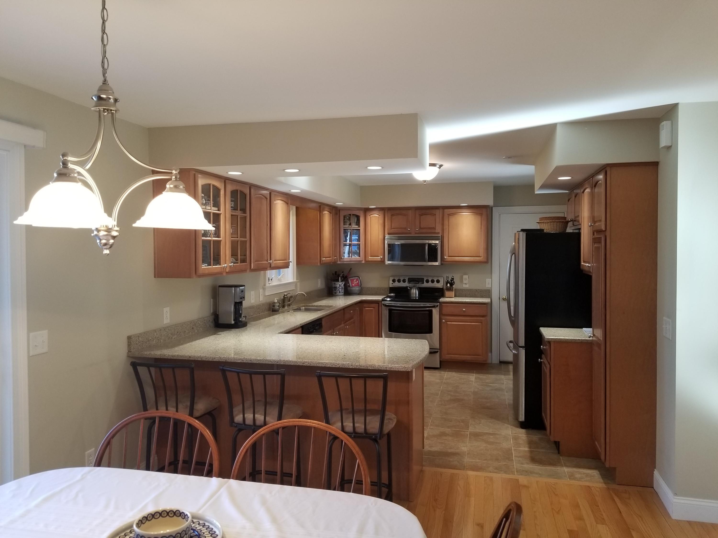 2 Easting Road Bourne, MA 02532 - Photo 9 of 34 a kitchen with stainless steel appliances kitchen island granite countertop a dining table chairs and a refrigerator