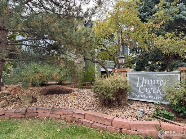 a view of a street with potted plants and large trees