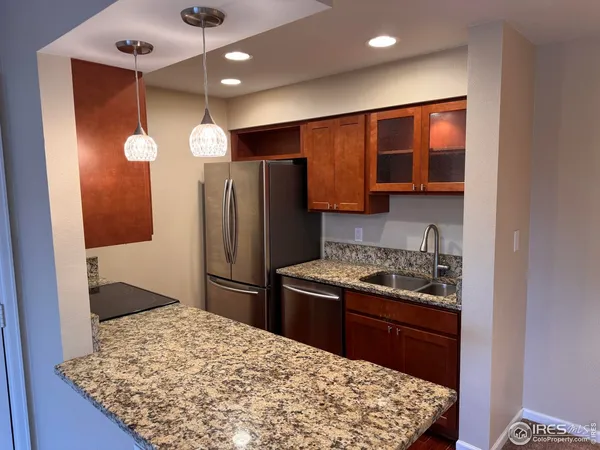 a kitchen with stainless steel appliances granite countertop a refrigerator and a stove