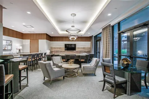 a living room with furniture kitchen view and a large window