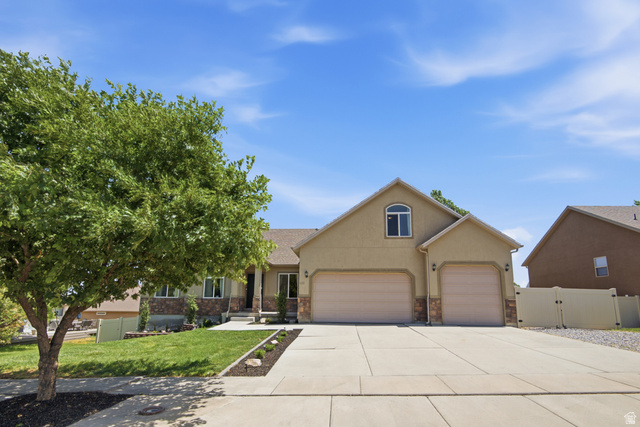 1252 Skyline Road Saratoga Springs, UT 84045 - Photo 5 of 51 Exterior features include a two-car garage, a separate single-car garage, a concrete driveway, stone accents, and manicured landscaping