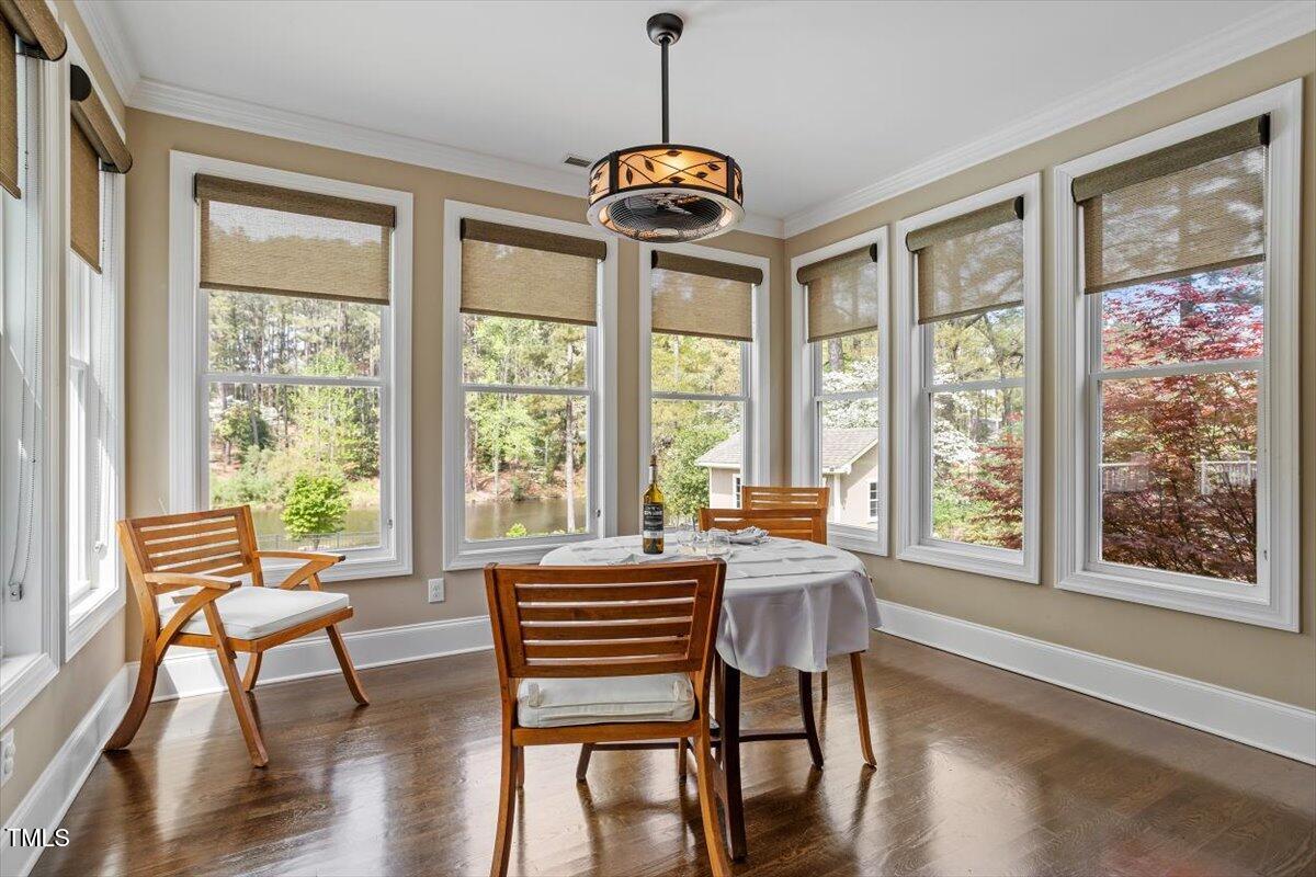 1422 Gormly Circle Sanford, NC 27330 - Photo 11 of 59 a dining room with wooden floor a chandelier a glass table and chairs