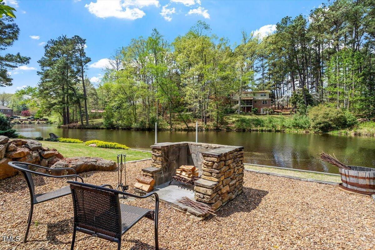 1422 Gormly Circle Sanford, NC 27330 - Photo 42 of 59 a view of a lake with table and chairs under an umbrella