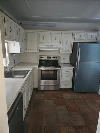 a kitchen with a stove sink and refrigerator