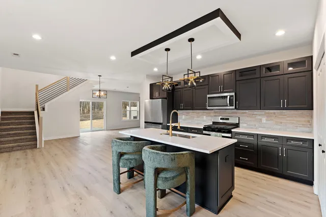a kitchen with kitchen island a cabinets counter top space a sink stainless steel appliances and cabinets