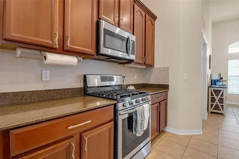 a kitchen with kitchen island granite countertop a stove and a sink