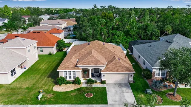 an aerial view of residential houses with outdoor space and trees