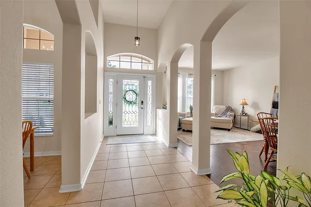 a dining room with furniture a chandelier and wooden floor