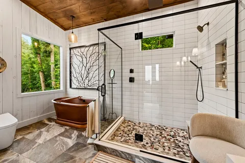 a bathroom with double vanity sinks and a shower