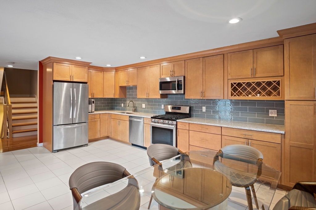 3 Mariners Way, Unit 3 Salem, MA 01970 - Photo 6 of 37 a kitchen with stainless steel appliances granite countertop a refrigerator a stove a sink a dining table and chairs with wooden floor