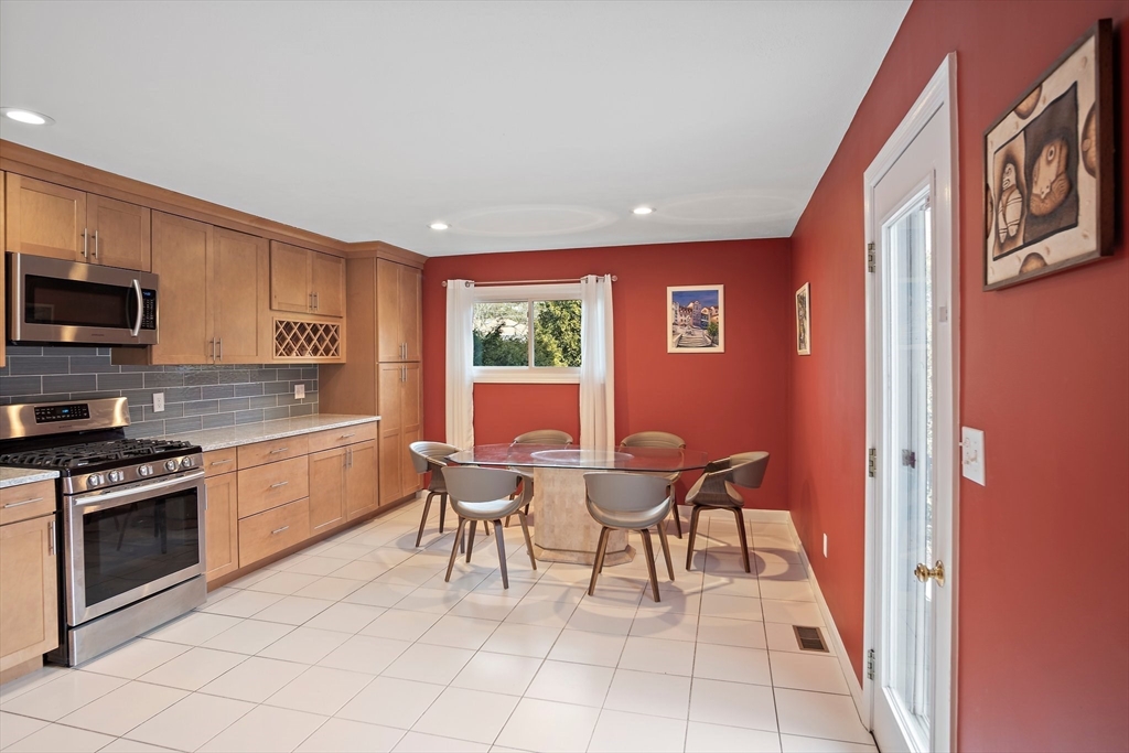 3 Mariners Way, Unit 3 Salem, MA 01970 - Photo 7 of 37 a kitchen with stainless steel appliances granite countertop a stove top oven a sink a dining table and chairs