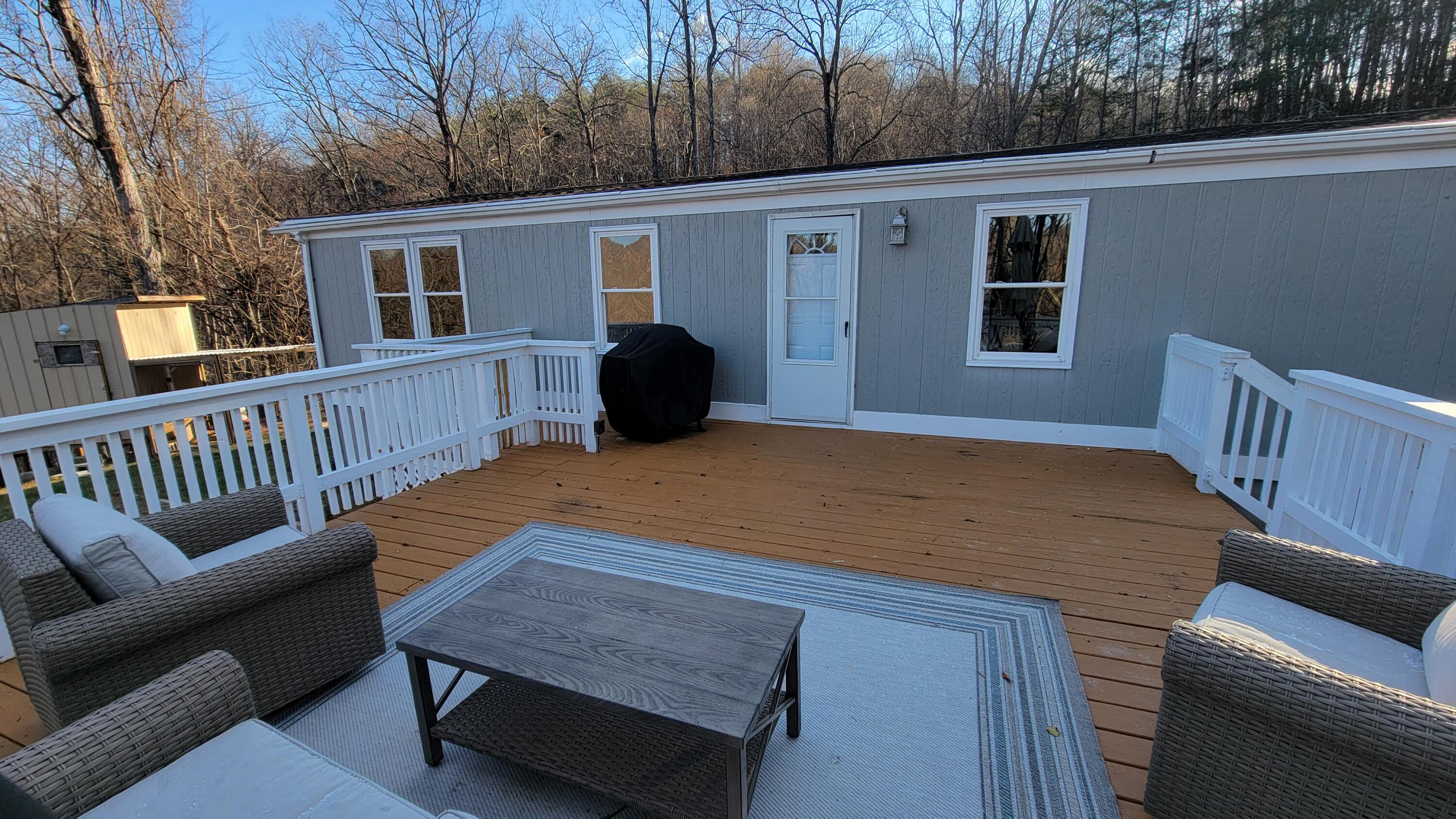 4350 Mountain View Church Road Blue Ridge, VA 24064 - Photo 19 of 30 a view of a deck with couches table and chairs with wooden floor