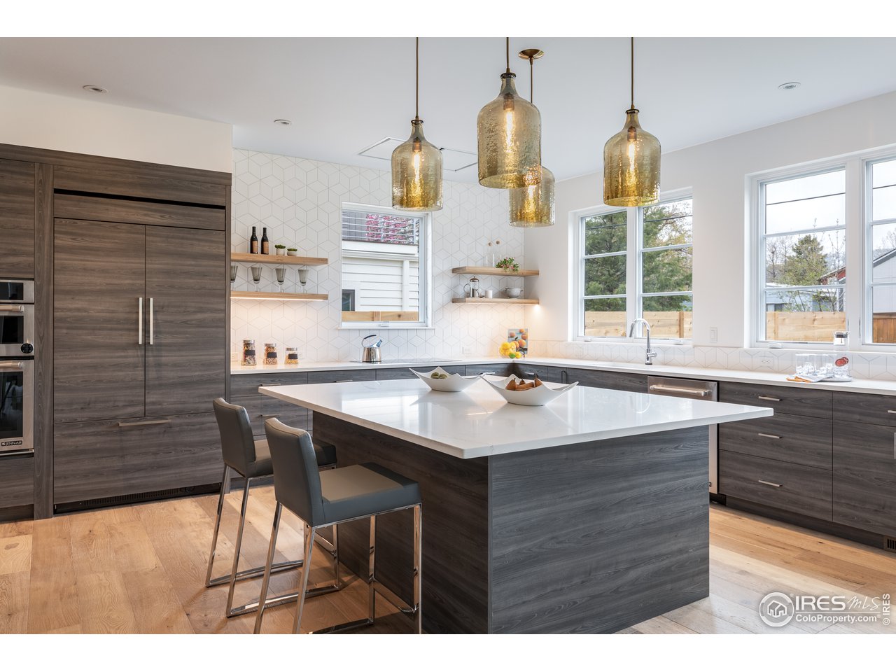 3025 18th Street Boulder, CO 80304 - Photo 4 of 35 a kitchen with stainless steel appliances kitchen island a table chairs in it and wooden floors