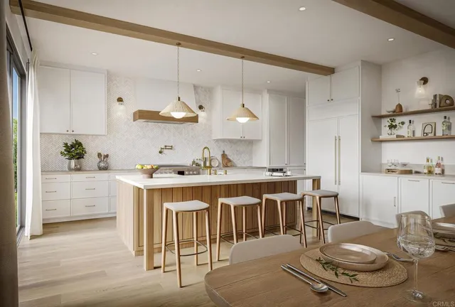 a kitchen with stainless steel appliances kitchen island granite countertop a table chairs stove and white cabinets