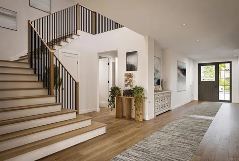 a view of a hallway with stairs and wooden floor