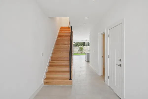 a view of a hallway with wooden floor and entryway
