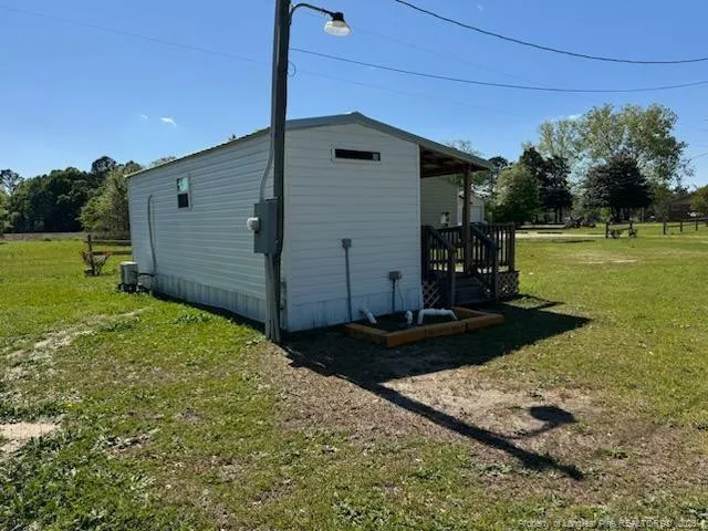 a view of a park with large trees and a wooden fence