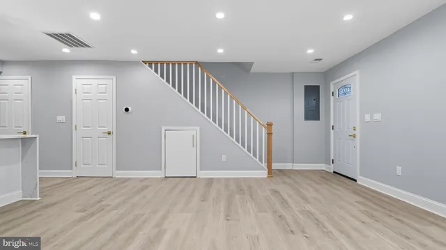 a view of a hallway with wooden floor and entryway