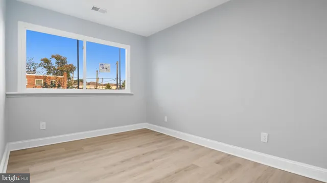 a view of a room with wooden floor and window