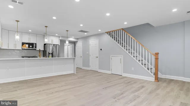a view of kitchen with kitchen island microwave and wooden floor