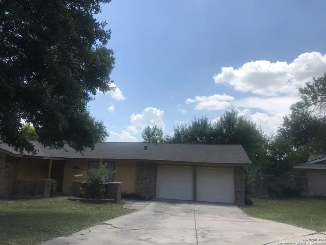 a front view of a house with a yard and a garage