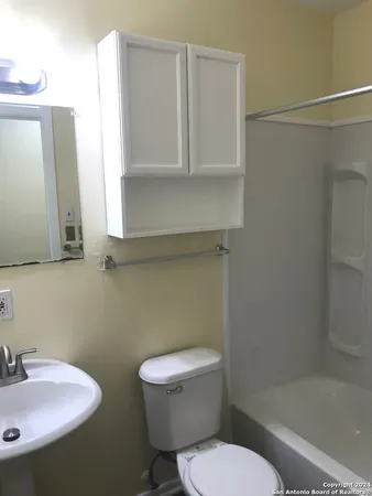 a white toilet sitting next to a bathroom sink