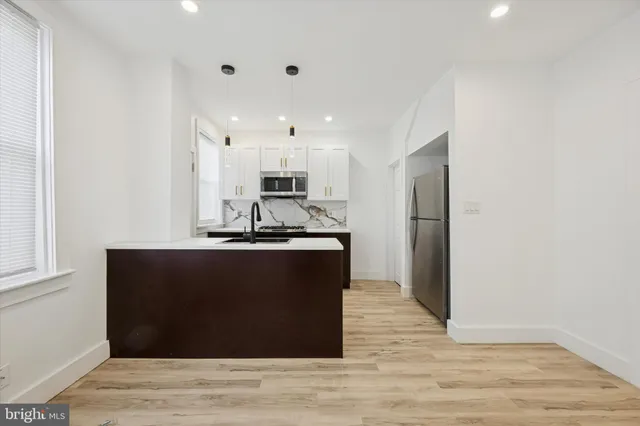 a kitchen with stainless steel appliances granite countertop a refrigerator and a sink