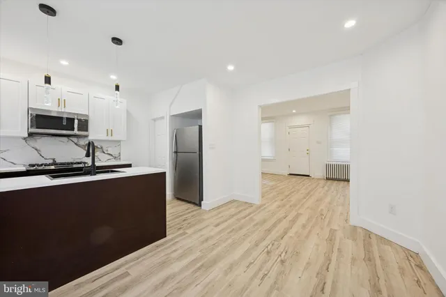 a kitchen with stainless steel appliances a refrigerator sink and microwave