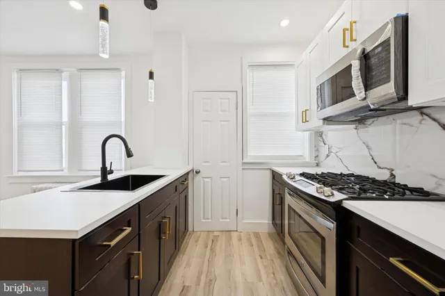 a kitchen with stainless steel appliances a sink and a stove