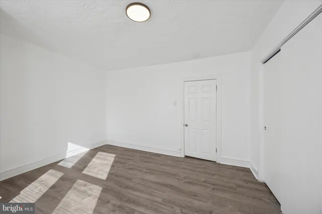 a view of a room with wooden floor and white walls