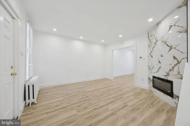 a view of empty room with wooden floor and fireplace