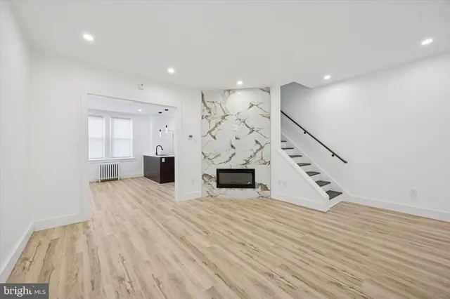 a view of a livingroom with wooden floor and staircase