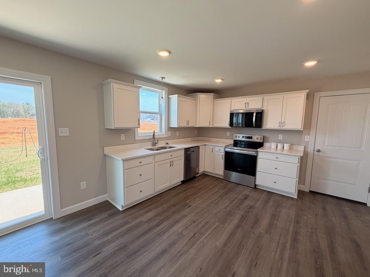 306 Rine Drive Shippensburg, PA 17257 - Photo 7 of 18 a kitchen with wooden floors white appliances white cabinets and a window